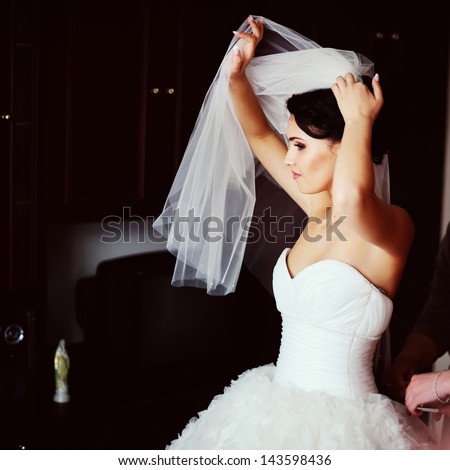Gorgeous brunette  bride is getting dressed  in the morning