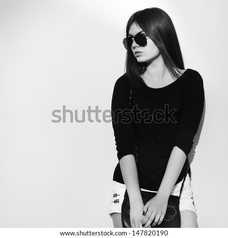 young cute woman wearing sunglasses, street portrait in black and white