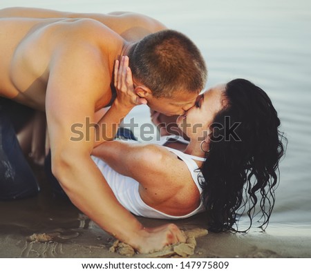 sensual young couple at beach kissing hot