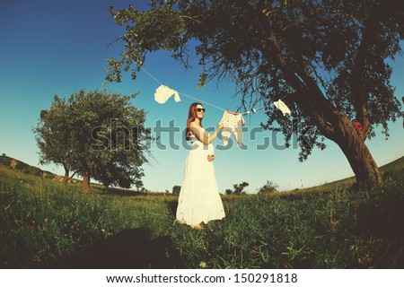 human pregnancy, cute pregnant woman in garden, wide angle shot
