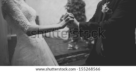 hands of a young newly wed couple, black and white