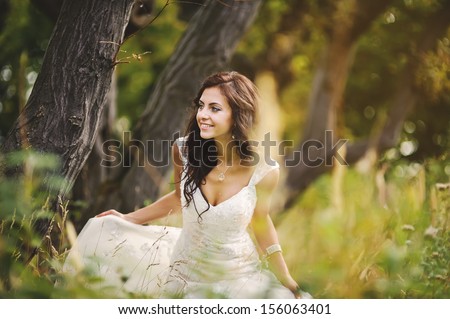 young bride enjoying walking in autumn forest
