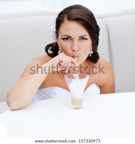 Beautiful brunette bride drinking cappuccino in cafe. Best cappucino ever.