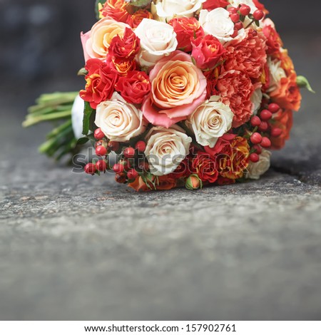 Beautiful Bridal bouquet of various flowers on asphalt.
