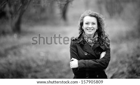 Cute smile ever. Curly hair girl wearing coat. Portrait in black and white