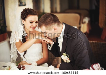 Groom kissing hand of his lovely bride.