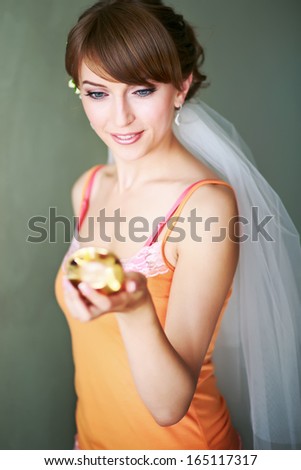 Gorgeous bride looking into mirror, getting ready in the morning.
