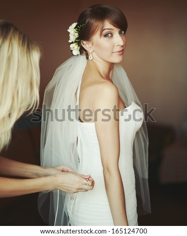 Young bride getting dressed in the morning.
