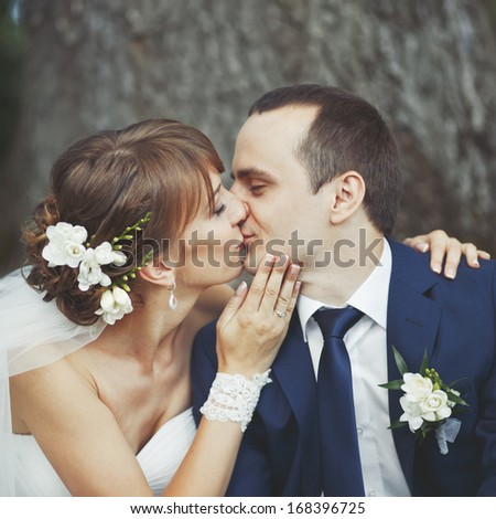 Bride kissing groom, wedding couple together.