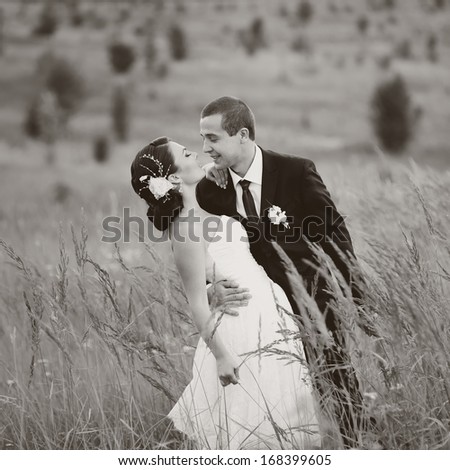 Wedding couple together in field. Black and white.
