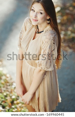 Natural portrait of young beautiful woman outside. Caucasian woman with long hair wearing dress on sunny summer day.