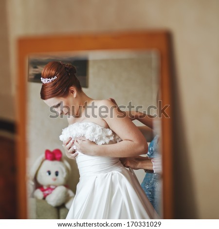 Bridal morning in the mirror. Bride getting dressed in the morning.