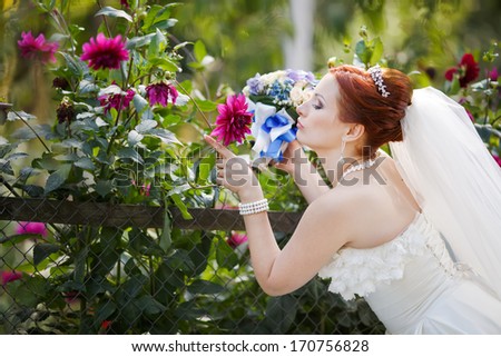Red hair young bride posing with flowers.