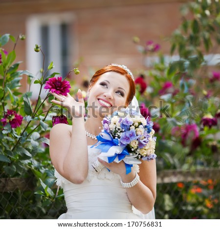 Young lovely red hair young bride posing with flowers.