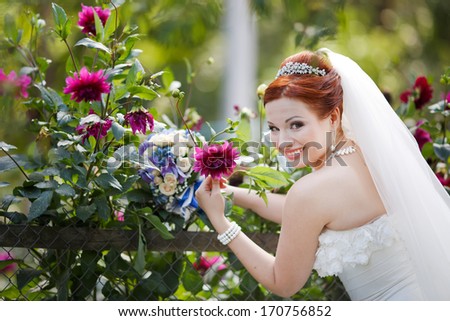 Red hair young bride posing with flowers.