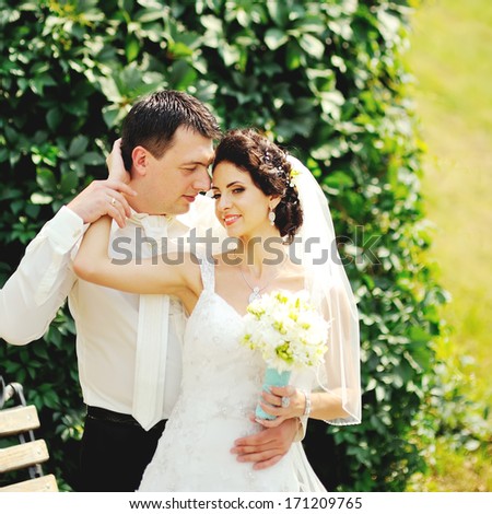 Symbol of togetherness.  Young caucasian wedding couple embracing.