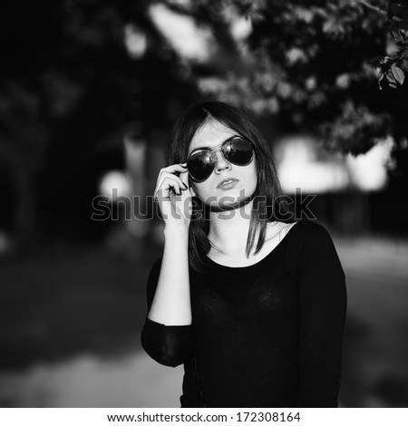 Young woman  wearing black shirt  on sunny summer day. Portrait in black and white.