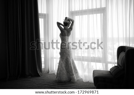 Silhouette of gorgeous bride in hotel room.  Black and white wedding picture.