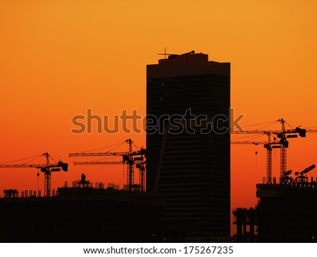 Industrial construction crane against sunset in Dubai city