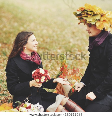 Wreath of leaves. Young couple having date in autumn park.