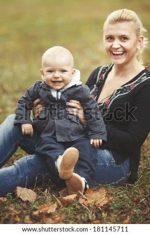 Young mother spending great time with her lovely son in garden.