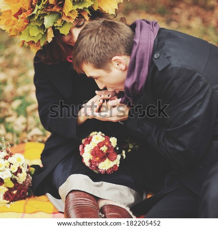 I will warm your hands, darling. Young sweet couple having date in autumn park.