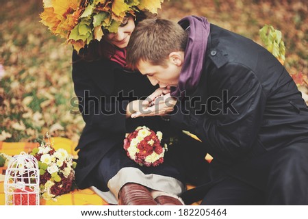 I will warm your hands, darling. Young sweet couple having date in autumn park.