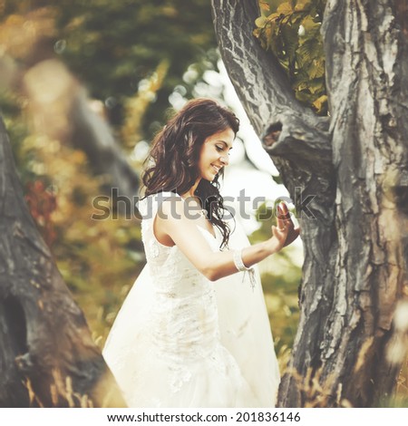 Young beautiful bride enjoying walking in magic forest