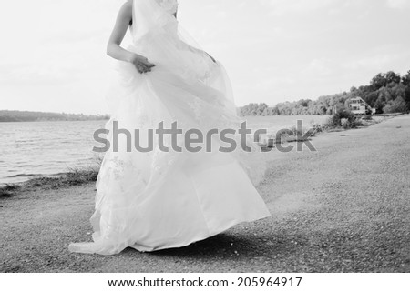 Caucasian beautiful bride spinning around with veil in hand. Summer wedding day.