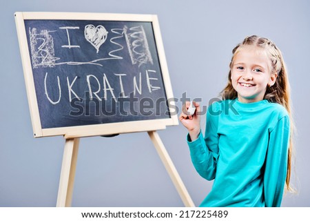 I love Ukraine, cute kid writing on black board.