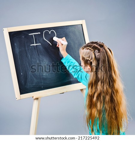 I love, cute kid writing on black board.