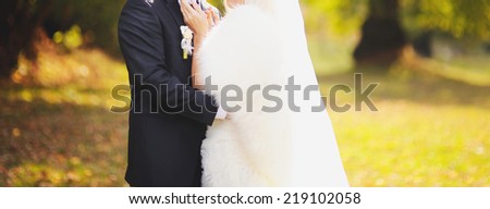 Newly wed couple holding hands, autumn wedding.