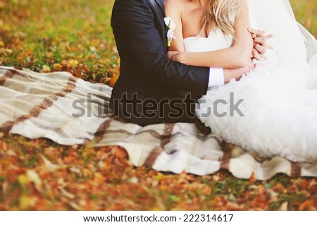 Newly wed couple holding hands, autumn wedding.