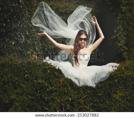 Stylish bride with flying veil. Young happy  fiancee in park.