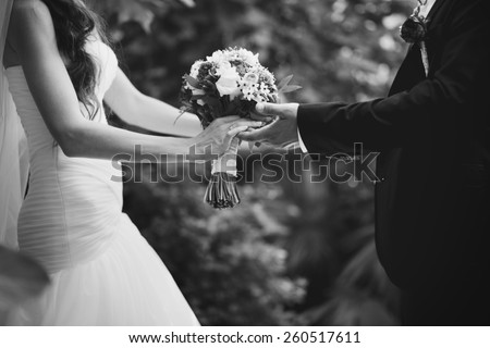 Hands of newlywed couple in love, wedding on summer day.  Picture in black and white.