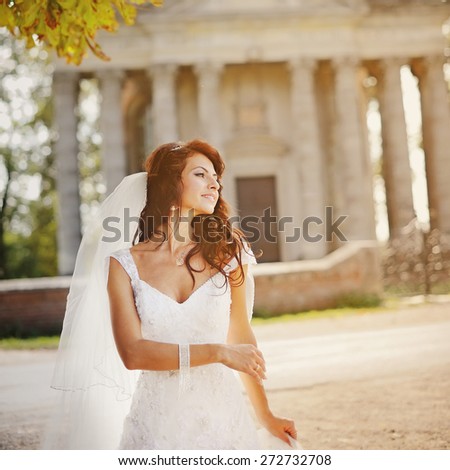 Beautiful young bride posing against old church.