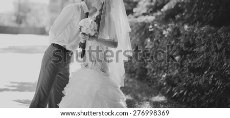 Happy bridal couple in forest. Summer wedding picture in black and white.