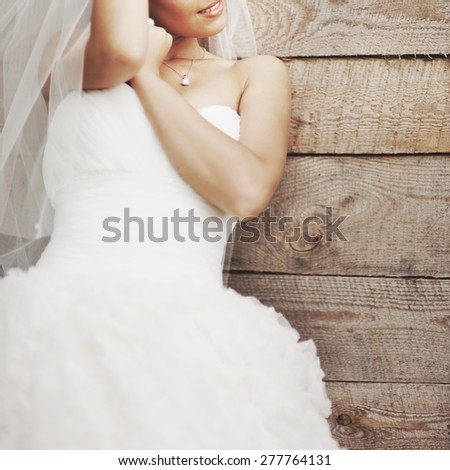 Wedding picture of happy bride against wooden background.
