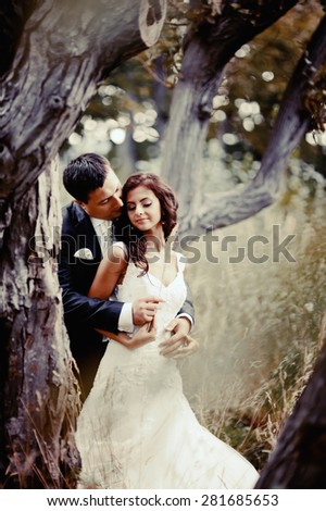 Happy bridal couple in forest. Summer wedding picture.
