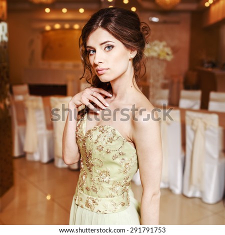 Teenage girl wearing fancy prom dress, posing on  school-leaving party.