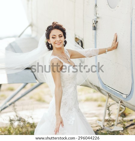 Wedding couple together posing against airplane. Bride and groom having fun next to old aircraft.