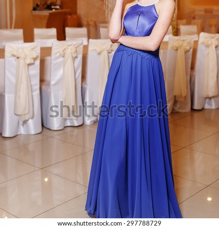 Interior portrait of young brunette woman wearing blue prom dress.  Graduate student.