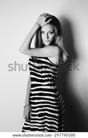 Fashion black and white portrait of young log hair woman wearing zebra dress.