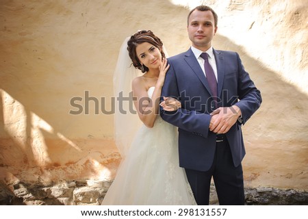 Bridal couple together posing at street. Happy summer wedding.