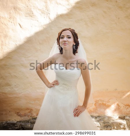 Bride next to old building wall. Summer wedding.