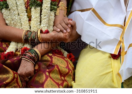 Paani Grahanam ritual during a Hindu Wedding. The groom with his right hand holds the right hand of the bride. This symbolizes the bride surrendering her heart in the hands of the groom.