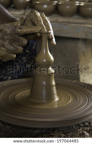 An artist and expert potter giving the firmly shaping up the clay vase. Clay molding is a means of livelihood for hundreds in India.