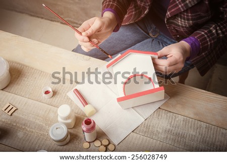 Top view of  women\'s hands during  handcrafting a decorative house