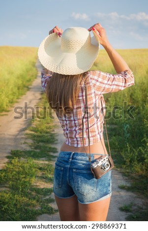 Portrait of young  beautiful woman from behind with retro camera