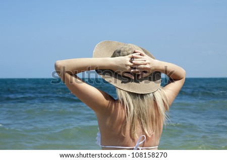 the girl in the hat looks back at sea